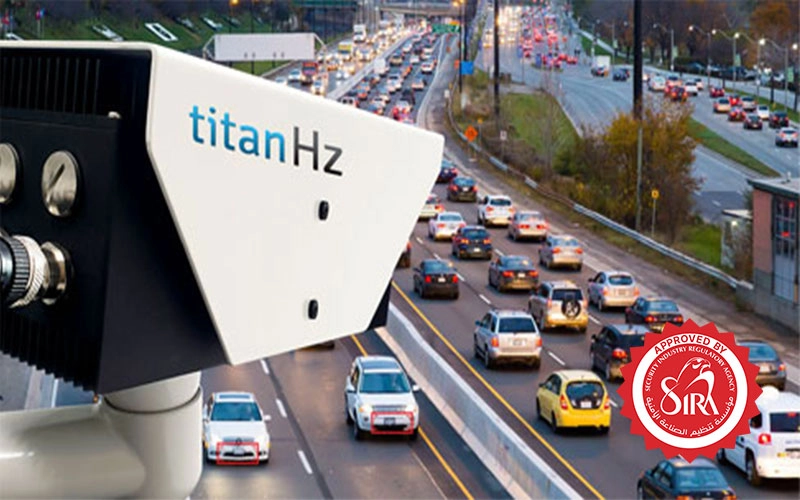 a titanhz anpr camera mounted above, monitoring multiple cars as they pass through, showcasing real-time vehicle tracking.