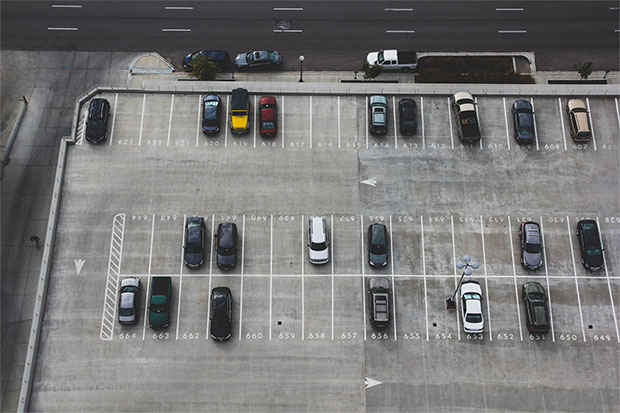 top view of an outdoor parking lot with multiple cars parked, showcasing a well-organized parking area for efficient vehicle management.