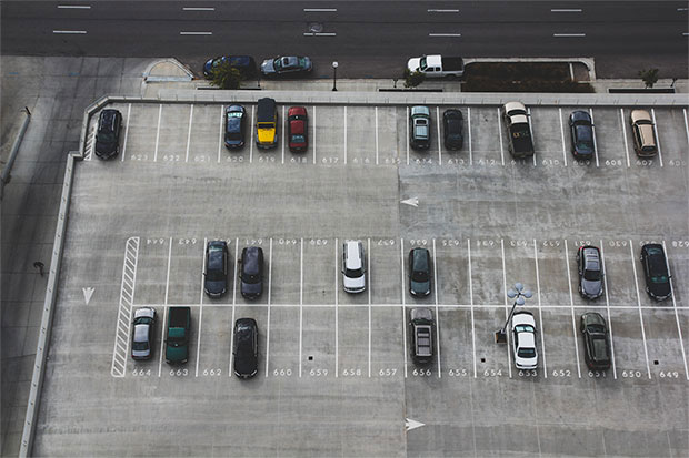 top view of an outdoor parking lot with multiple cars parked, showcasing a well-organized parking area for efficient vehicle management.