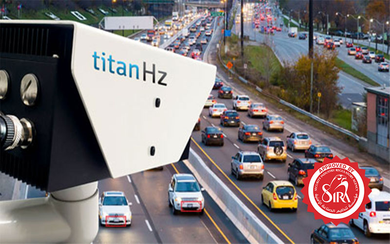 a titanhz anpr camera mounted above, monitoring multiple cars as they pass through, showcasing real-time vehicle tracking.