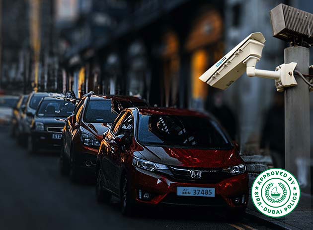 a city scene with multiple cars parked roadside and a titanhz anpr camera monitoring vehicles for security and management solutions.