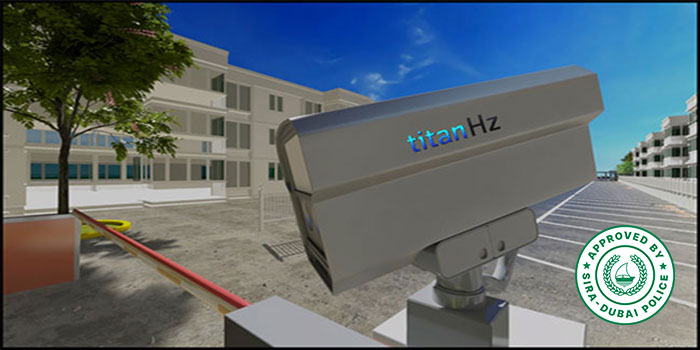 a parking area with buildings in the background, a titanhz anpr camera mounted at the entrance, and a boom barrier for access control.