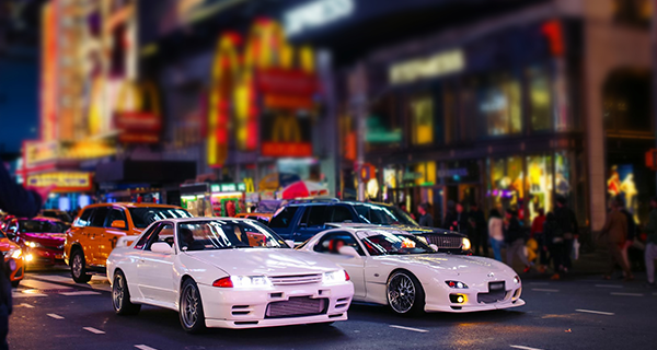 a city scene with multiple cars passing and buildings in the background, showcasing vehicle monitoring with anpr security systems.