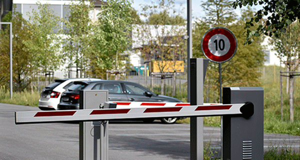 a parking zone with a boom barrier in front and cars parked in the background, showcasing cost-effective parking solutions.