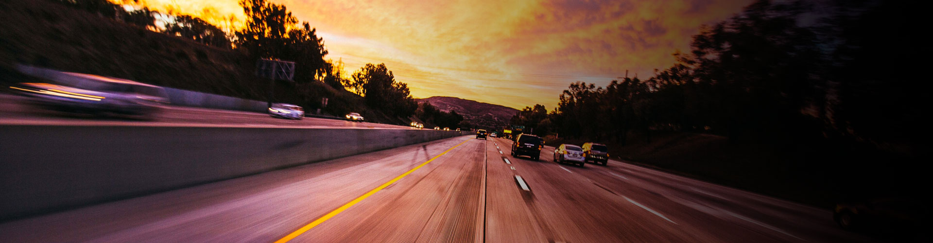 a banner image of a highway with multiple cars running and blurred sides, showcasing anpr intelligent transport systems.