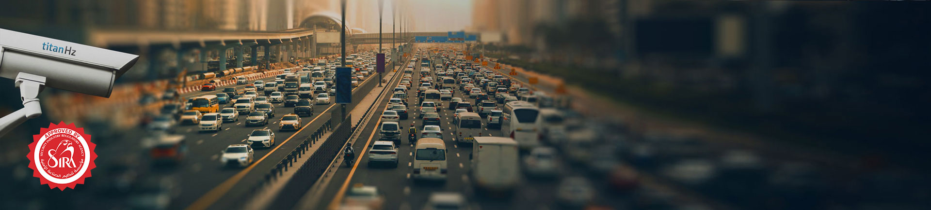 a city road with two lanes, multiple cars driving, and an anpr camera monitoring traffic for automated control solutions.